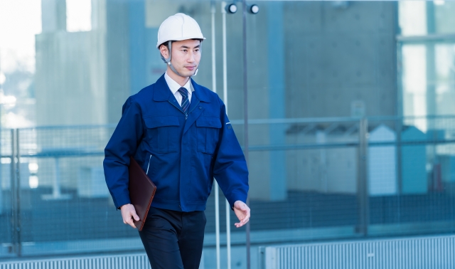 歩く作業服を着た男性