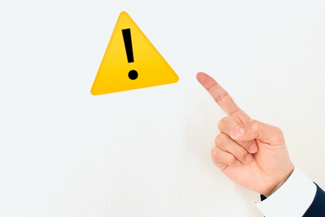 注意マークを指差す手